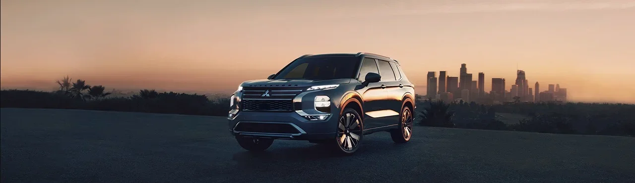 a mitsubishi outlander on a road with a sunset